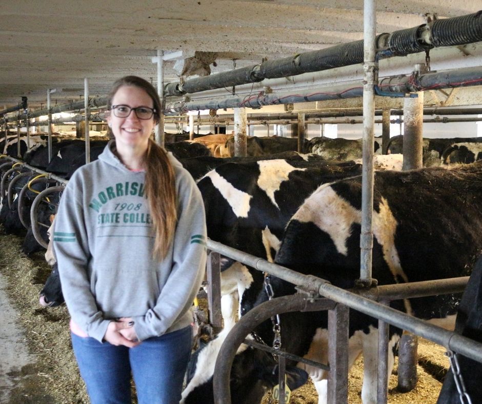 Jen Ploetz stands with cows at her dairy farm. 