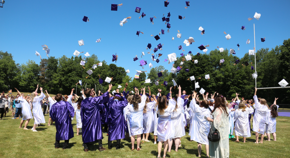 Students flip caps in the air.