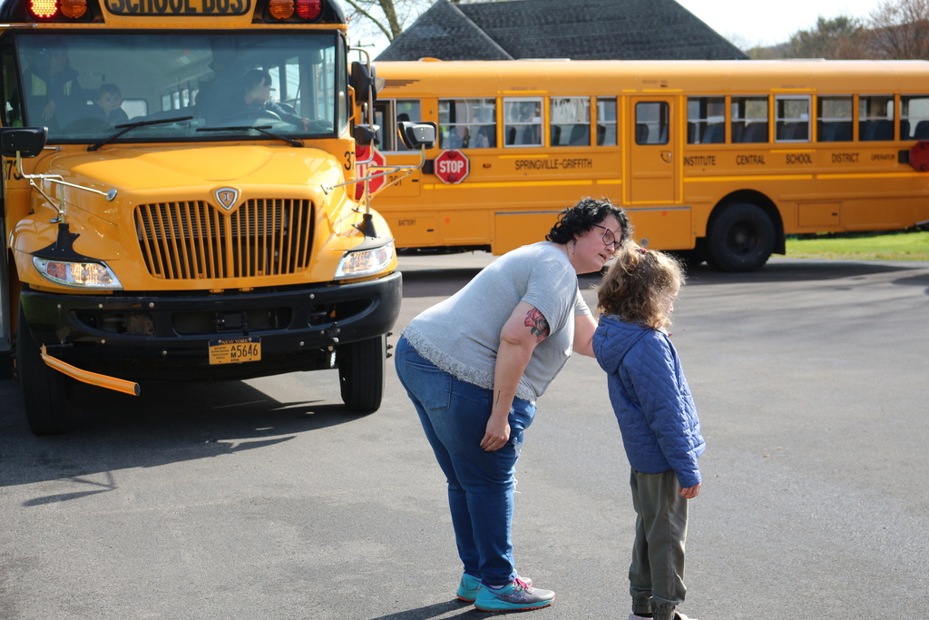 A bus monitor explains crossing procedures to a student at Colden Elementary School.
