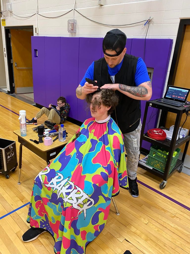 A student gets their hair cut.