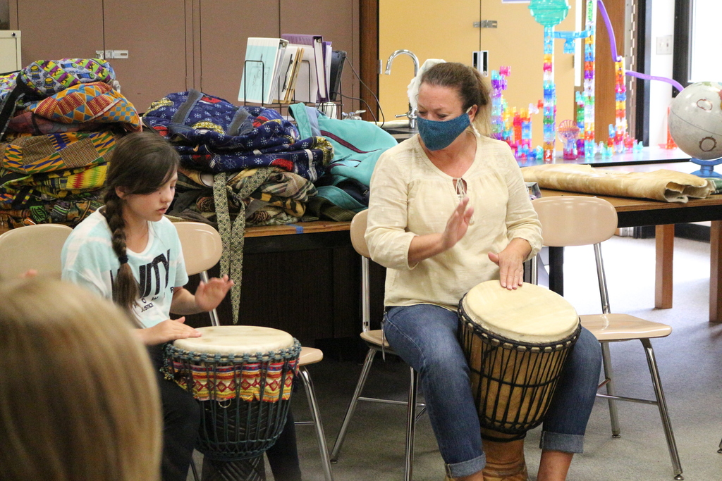 A student and teacher drum together