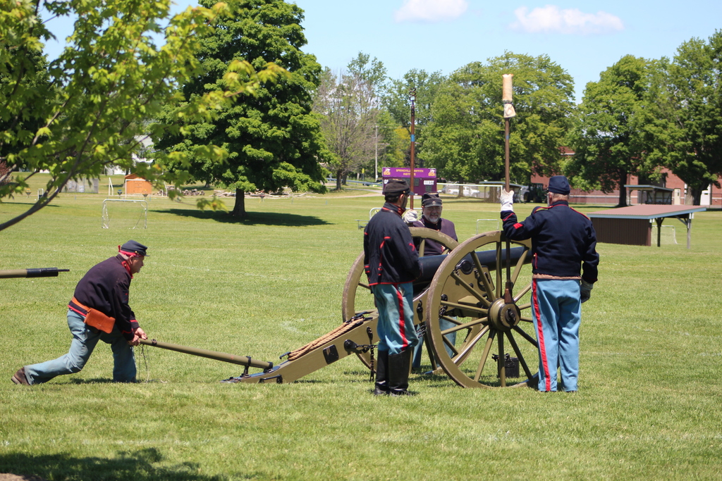 Members of the Reynolds Company light a canon. 