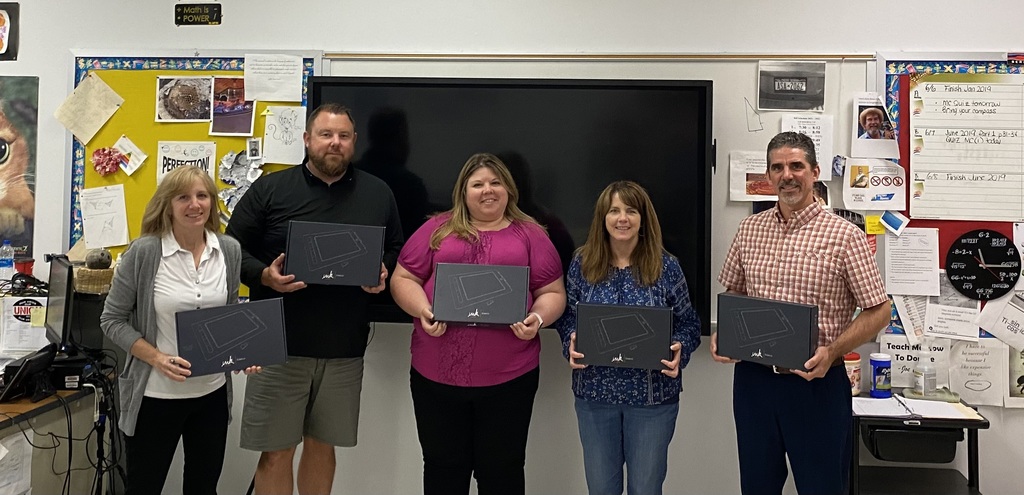 Teachers holding boxes of new tablets.